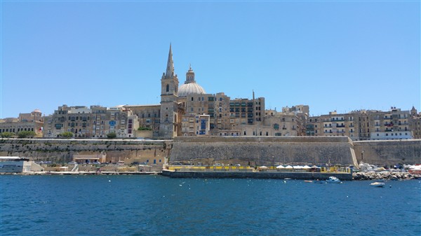 Blick über das tiefblaue Meer auf die historische Festungsstadt Valletta mit ihren charakteristischen Kuppeln und Mauern auf Malta